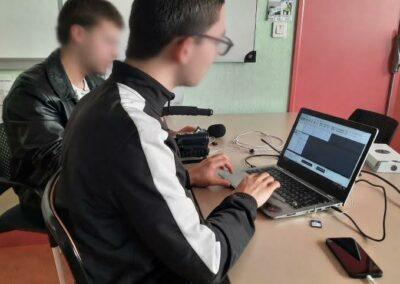 lycéen faisant du montage audio sur un pc portable