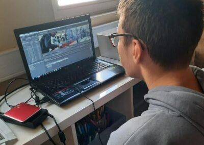 lycéen faisant du montage vidéo sur un pc portable