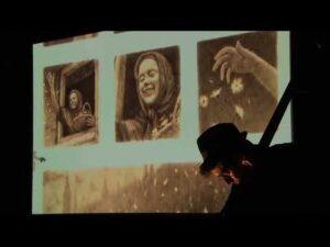 A droite Florent Hermet est penché sur sa contrebasse. Au fond des cases de l'album Là où vont nos pères sont projetées sur un écran blanc. 