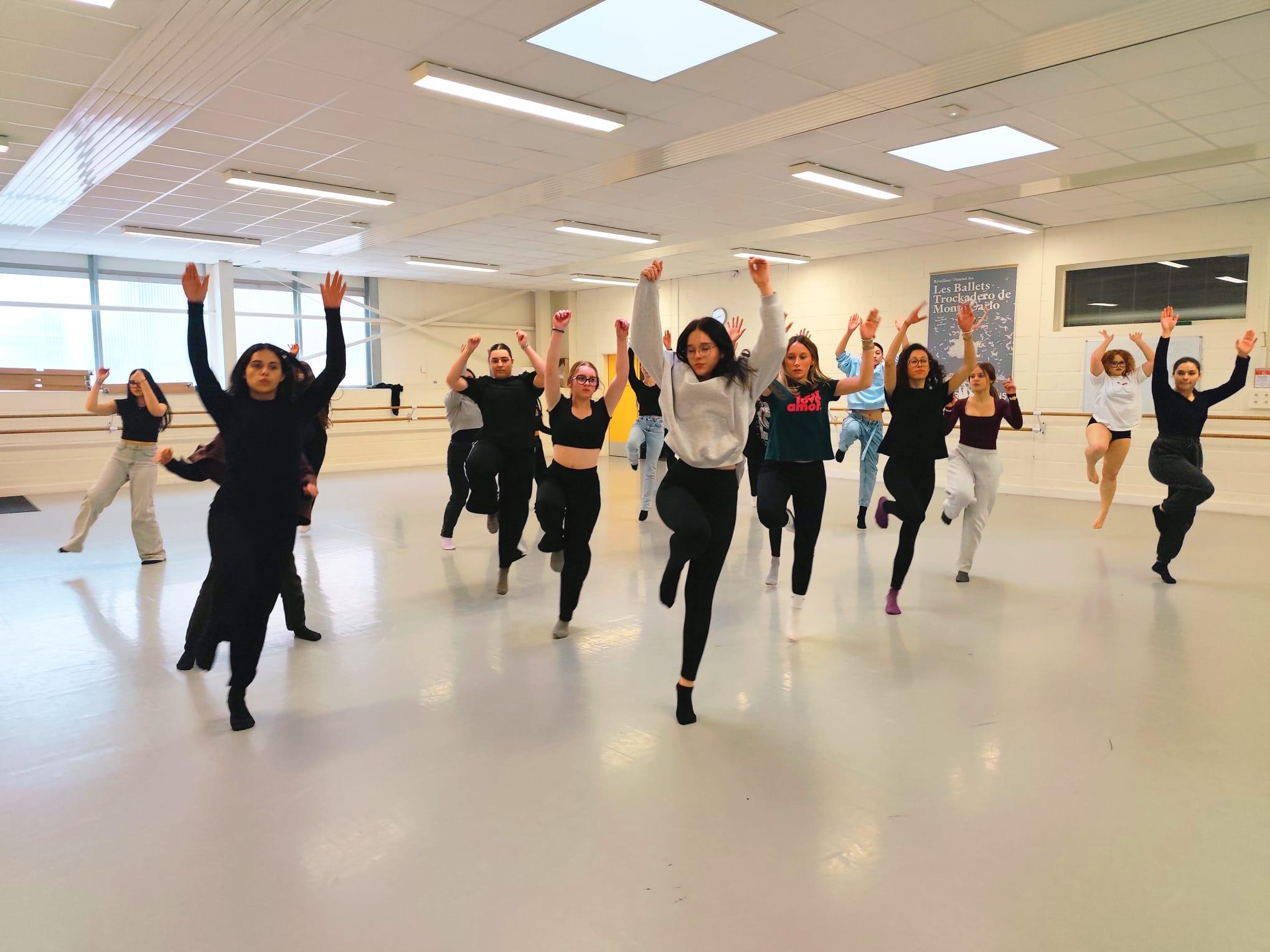 Les danseuses Sautent sur une jambe en levant les bras. Dans le studio danse du conservatoire. 